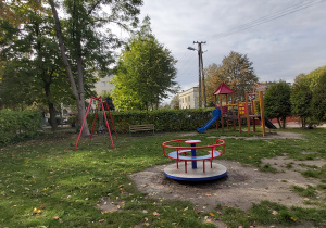 plac zabaw, na którym znajduje się karuzela, zamek ze zjeżdżalnią, dwie huśtawki. Po lewej stronie placu, a także na wprost przy ogrodzeniu stoją ławki.