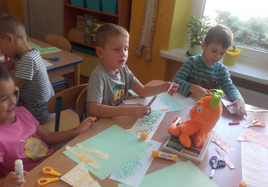 Inna grupa dzieci wycina elementy marchewki.