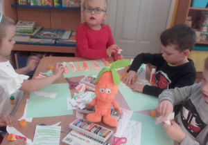 Dzieci przyklelają elementy marchewki.