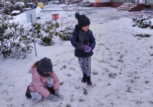 Widok na bawiące się na śniegu dzieci.