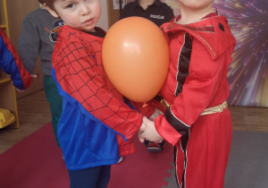 Adaś i Bartuś tańczą z balonikiem.