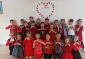 Dzieci pozują do zdjęcia w czerwonych strojach