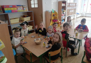 Dzieci zjadają posiłek przy stolikach