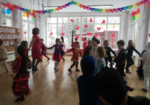 Dzieci w strojach karnawałowych tańczą na balu