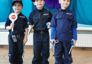 Widok na trzech chłopców w strojach policjantów.