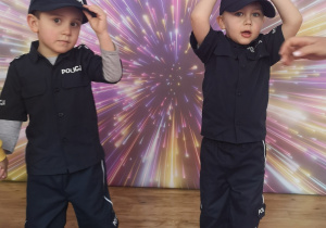 Widok na dwóch chłopców w strojach policjantów.