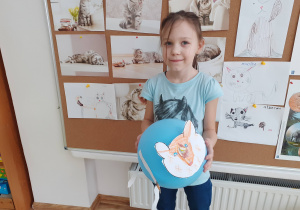 Dziewczynka prezentuje wykonanego przez siebie kota