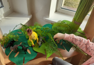 Dzieci odgrywają teatrzyk z dinozaurami