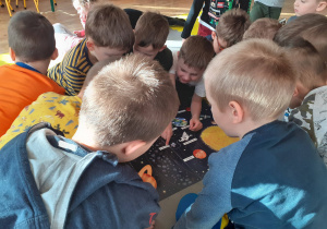 Dzieci obserwują plakat i nazywają planety układu słonecznego