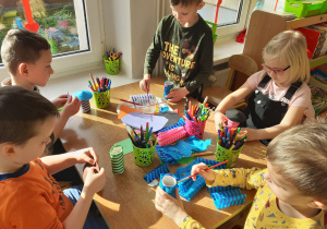 Dzieci z materiałów plastycznych konstruują rakietę.