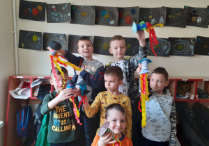 Chłopcy prezentują wykonane rakiety.