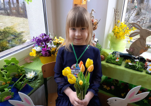 Dziewczynka pozuje do zdjęcia z kwiatami Dziewczynka pozuje do zdjęcia z kwiatami