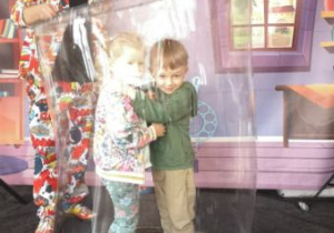 Widok na dwoje dzieci zamkniętych w bańce mydlanej.