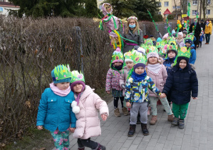 Widok na dzieci biorące udział w wiosennym przemarszu. Pani Magda niesie Marzannę.