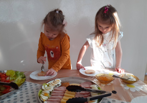 Widok na 2 dziewczynki korzystające ze "szwedzkiego stołu".