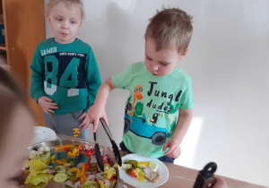 Jakub i Mikołaj przygotowują sobie kanapki przy "szwedzkim stole".