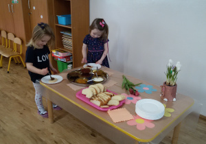 Widok na Marysię i Amelię, które korzystając ze "szwedzkiego stołu" przygotowują sobie kanapki.