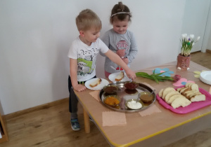 Laura i Oluś przygotowują sobie kanapki korzystając ze "szwedzkiego stołu".