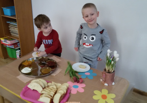 Bartosz i Jakub przygotowują sobie kanapki stojąc przy "szwedzkim stole".