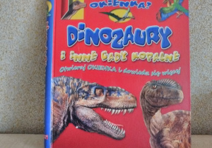 Okładka książki z napisem "Dinozaury i inne gady kopalne”. W tle sylwetki 2 dinozaurów.