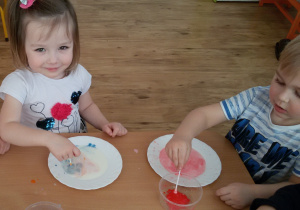 Marysia i Oluś malują farbami na mleku.