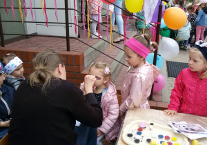 Widok na dzieci korzystające z atrakcji malowania twarzy.
