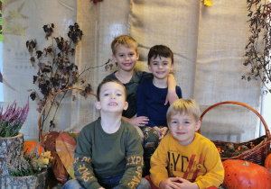 Grupa chłopców pozuje do zdjęcia na jesiennym tle.