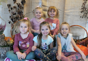 Grupa dziewczynek pozuje do zdjęcia na jesiennym tle.