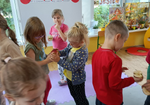 Dzieci poruszają się przy muzyce i dopasowują połówki jabłek.