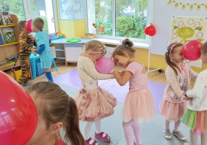 Dzieci tańczą w parach z balonem umieszczonym między głowami.