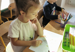 Dziewczynka i chłopiec rysują jabłonkę oraz jabłka.