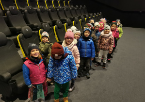 Uśmiechnięte dzieci ustawili się, aby wyjść z sali kinowej.