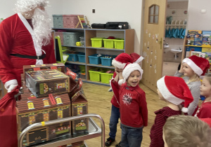 Grupa dzieci wita Świętego Mikołaja.