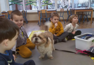 Widok na roześmiane dzieci w towarzystwie pieska Kędziora.