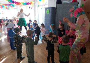 Tańczące dzieci w kółeczku na balu karnawałowym.