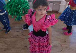 Dziewczynka w stroju karnawałowym tańcząca z pomponem.