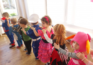 Widok na dzieci tworzące pociąg podczas tańca na balu karnawałowym.