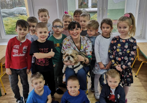 Dzieci pozują do zdjęcia wraz z Panią weterynarz i jej psem.
