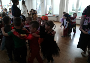 Dzieci tańczą do muzyki w sali balowej.