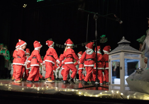 Dzieci w strojach Mikołaja tańczą podczas występów w Łaskim Domu Kultury.