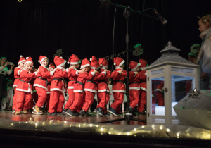 Dzieci w strojach Mikołaja tańczą podczas występów w Łaskim Domu Kultury.
