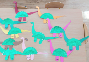 Widok na dinozaury wykonane przez maluszki z papierowych talerzyków.