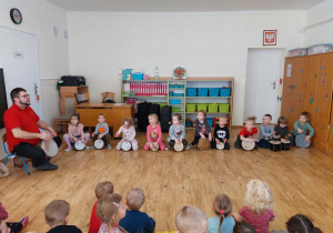 Grupa dzieci grająca na bębnach.