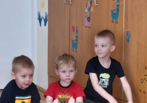 Trzech chłopców gra na bębnach.