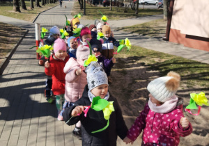Dzieci idące ulicami miasta z okazji Pierwszego Dnia Wiosny.