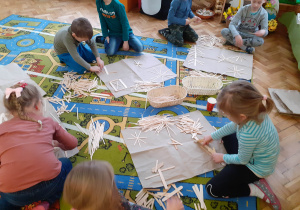 Dzieci bawią się drewnianymi patyczkami.