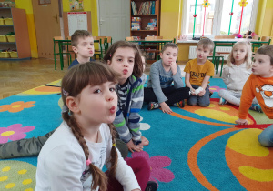 Dzieci wykonują ćwiczenia oddechowe.