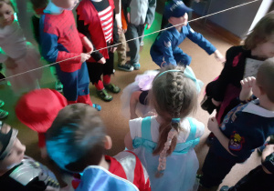 Dzieci w strojach karnawałowych przechodzą pod linią