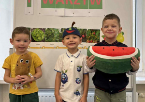 Widok na dzieci pozujące w strojach z okazji Dnia Owoców i Warzyw.
