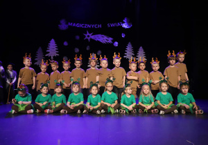 Widok na dzieci pozujące do zdjęcia na tle dekoracji w Łaskim Domu Kultury.